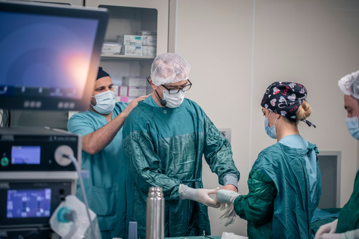 Equipo médico preparándose para cirugía en quirófano hospitalario