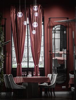 Luxurious dining space with elegant decor in a Baku restaurant, featuring stylish curtains and pendant lamps.