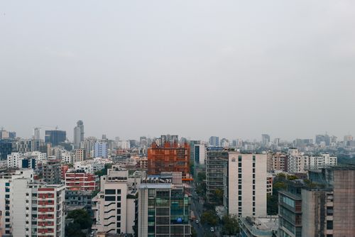 Free Aerial view of Dhaka, showcasing skyscrapers and urban skyline on a foggy day. Stock Photo