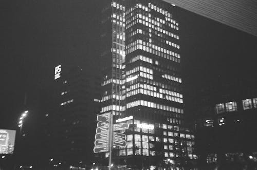 Grayscale Photo of a High Rise Building during Nighttime