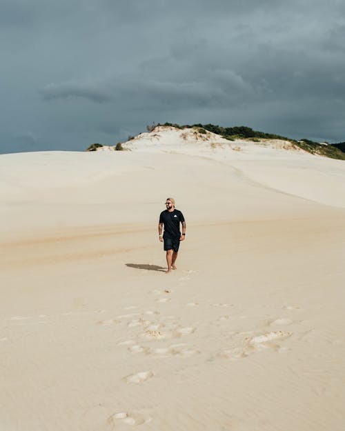 A Man Walking on White Sand