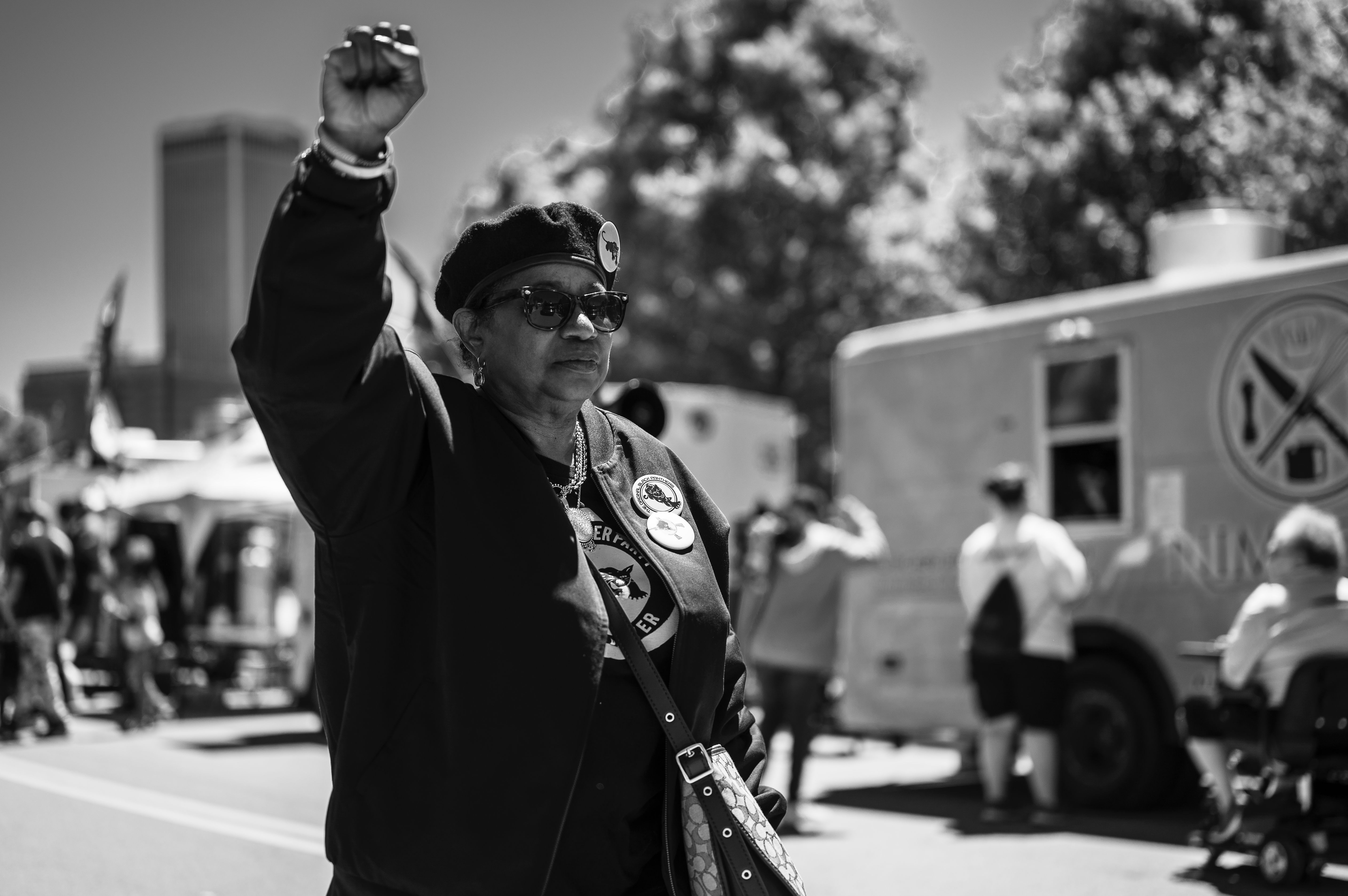 A woman raises her fist at a political rally in Tulsa, highlighting social activism.