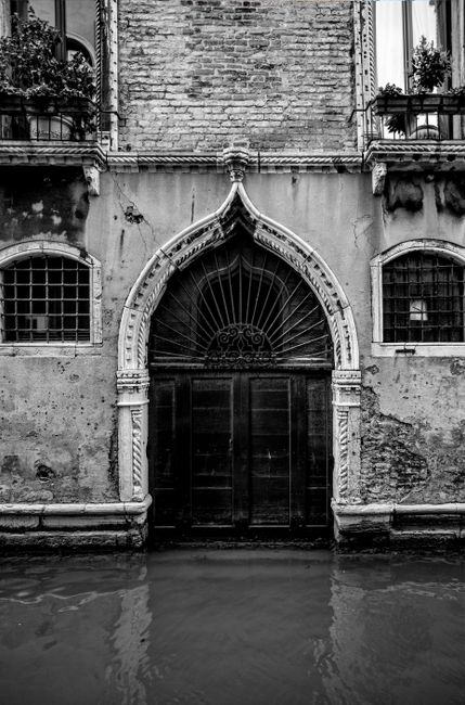 A striking black and white photo of a Gothic-style door in Venice. Perfect for travel and architecture enthusiasts.