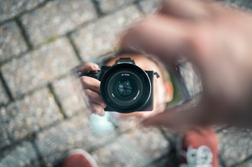 Selective Photo of Person Holds Black Dslr Camera