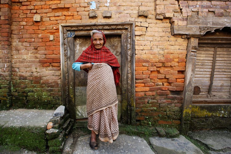 Elderly Woman Standing In Front Of The House 