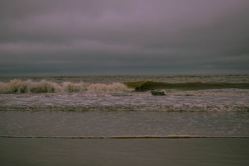 Free Peaceful waves lapping the shoreline under a moody sky along Argentina's coast. Stock Photo