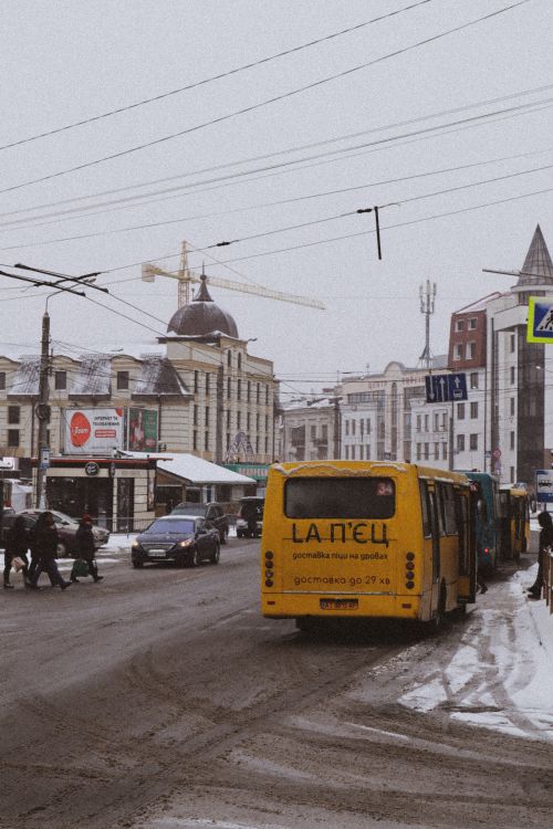 Free Lively city street in winter with snow, buses, and pedestrians. Ideal for urban scenes. Stock Photo