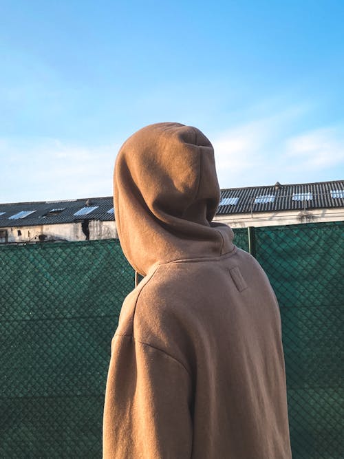 Free Close-Up Shot of a Person Wearing a Brown Hoodie Stock Photo