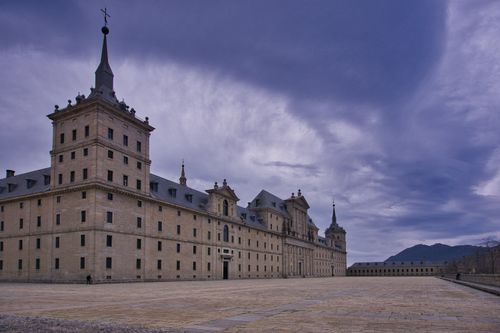 Free Explore the majestic El Escorial Monastery in Spain, framed by a vivid sky. Perfect for history and architecture enthusiasts. Stock Photo
