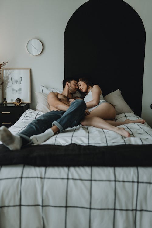 Free Young Couple Lying on Bed  Stock Photo