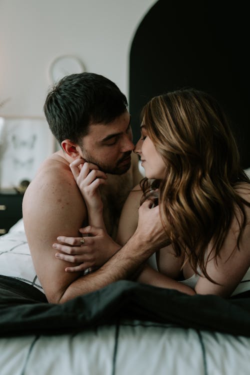 Free Young Couple Lying in Bed and Looking at Each Other  Stock Photo
