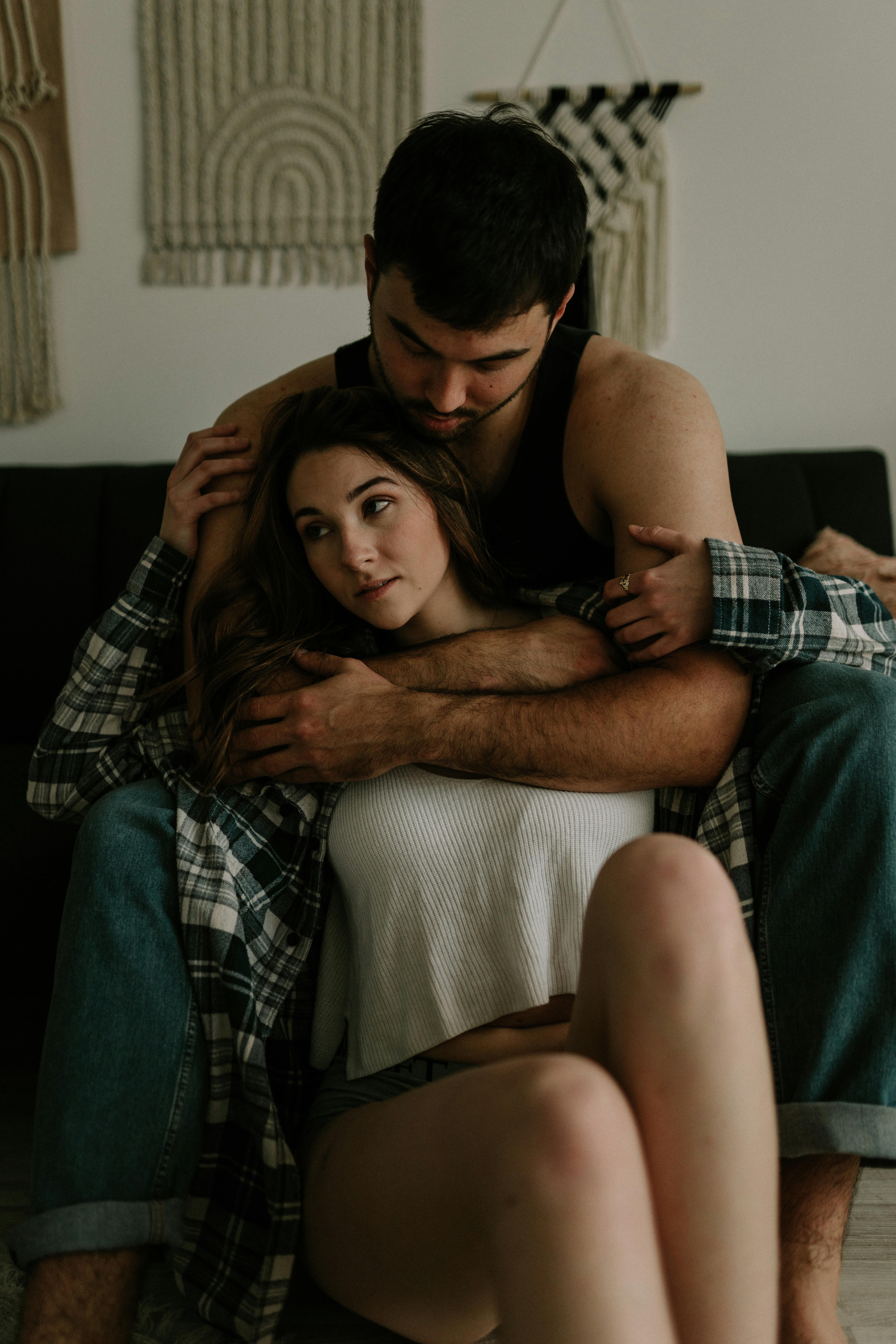 Woman Sitting on Her Partners Lap on a Sofa · Free Stock Photo