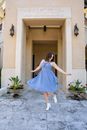 A Woman Wearing a Blue Dress at the Entrance of a Hotel