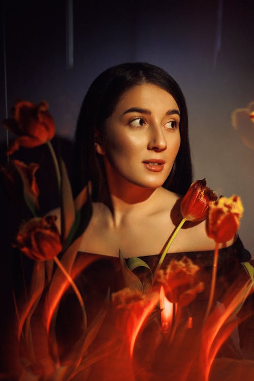 A Beautiful Woman Posing with Red Tulips