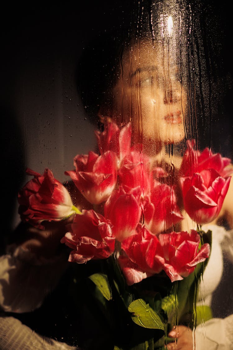 Woman With Flowers Behind Glass