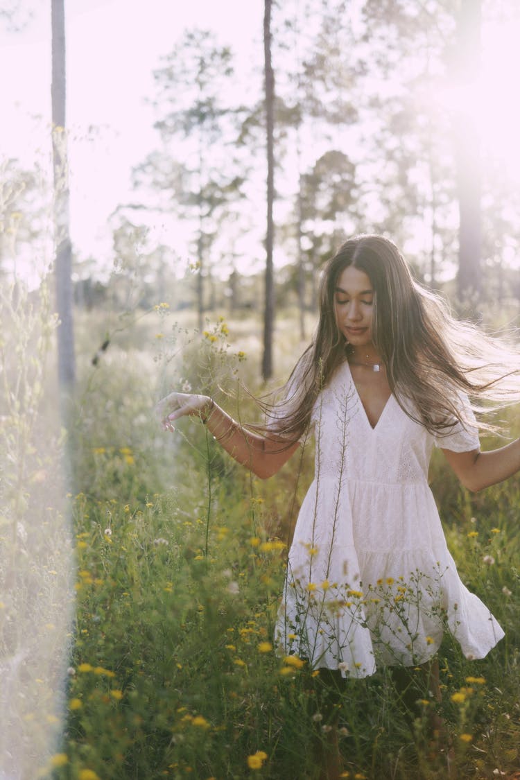 Woman In White Dress Walking Through Meadow