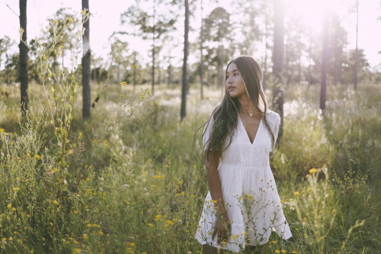 Woman In White Dress Walking Through Meadow