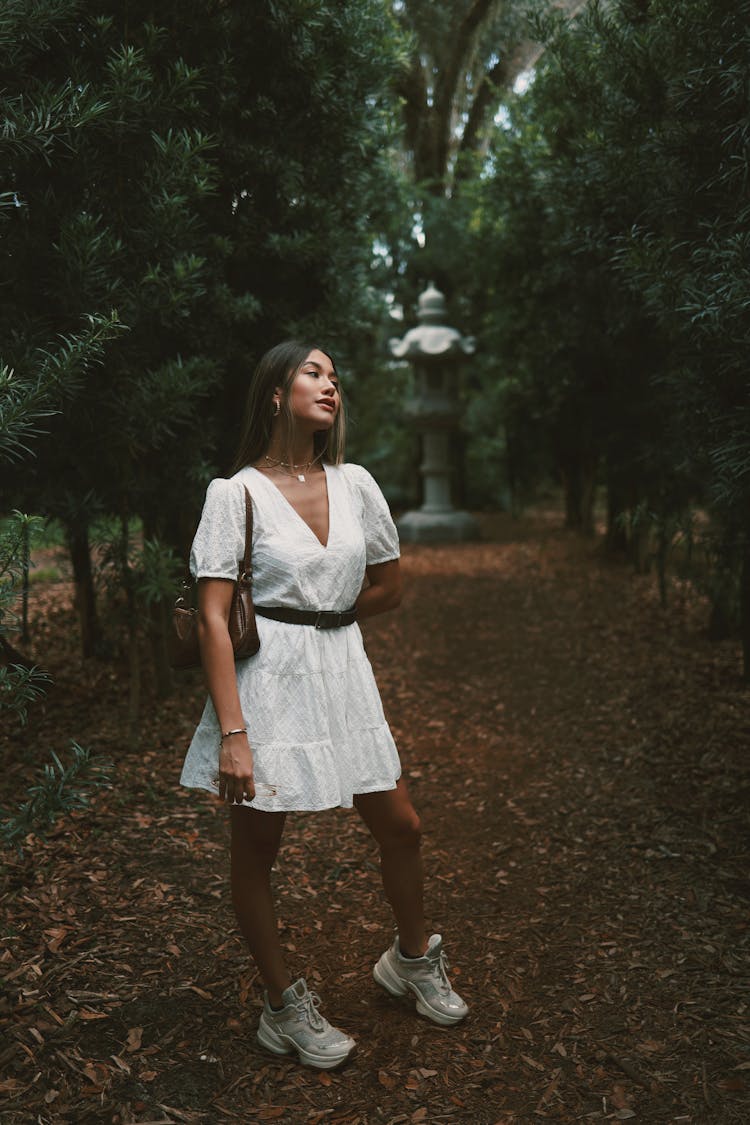 Woman In White Dress Standing In Dark Park Alley