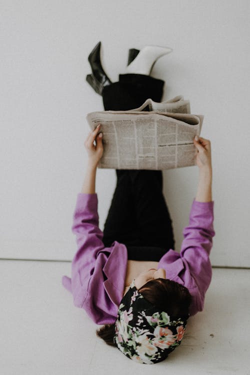 Fashion Woman Sitting on Floor and Reading Newspaper