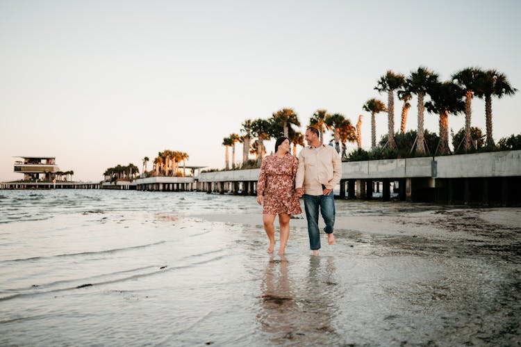 Happy Couple Holding Hands On Beach