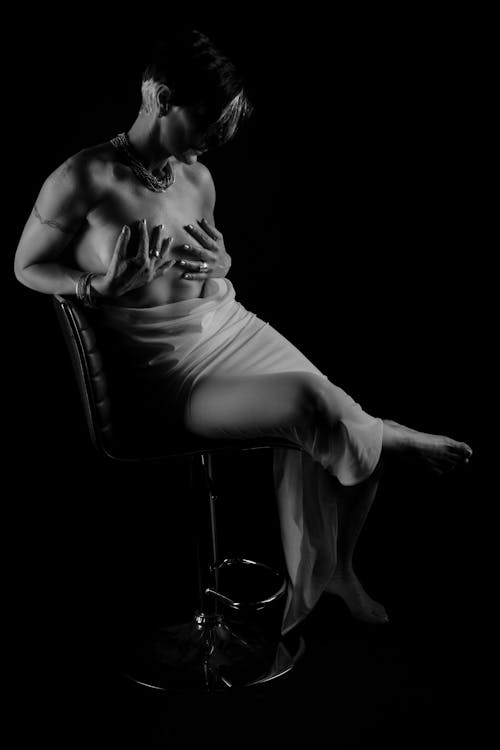 Black and White Photo of a Woman Sitting on Chair