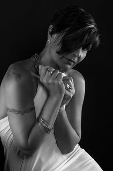 Striking grayscale portrait capturing the elegance of a woman posing gracefully in a studio setting.