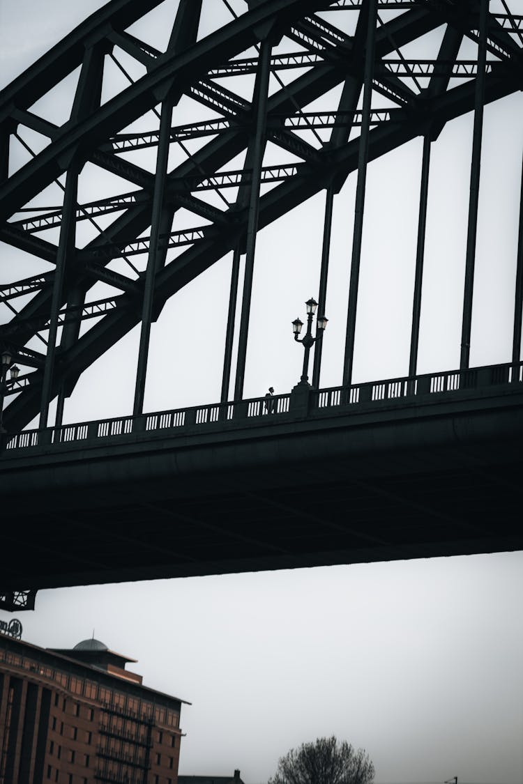 Silhouette Of Man Crossing Bridge