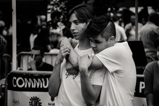 两个年轻人在街头人群中相拥，展现了友谊与联系