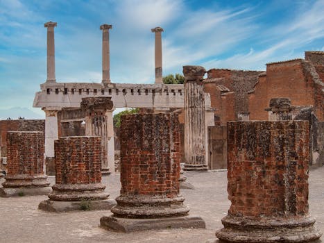 Explore the ancient brick columns and structures of historic Pompeii under a vibrant sky.