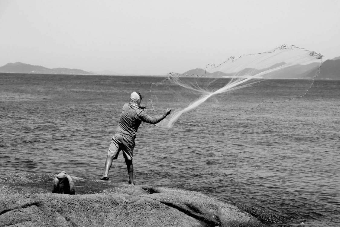 Black and White Photo of Fisherman Throwing Net into Water · Free Stock  Photo