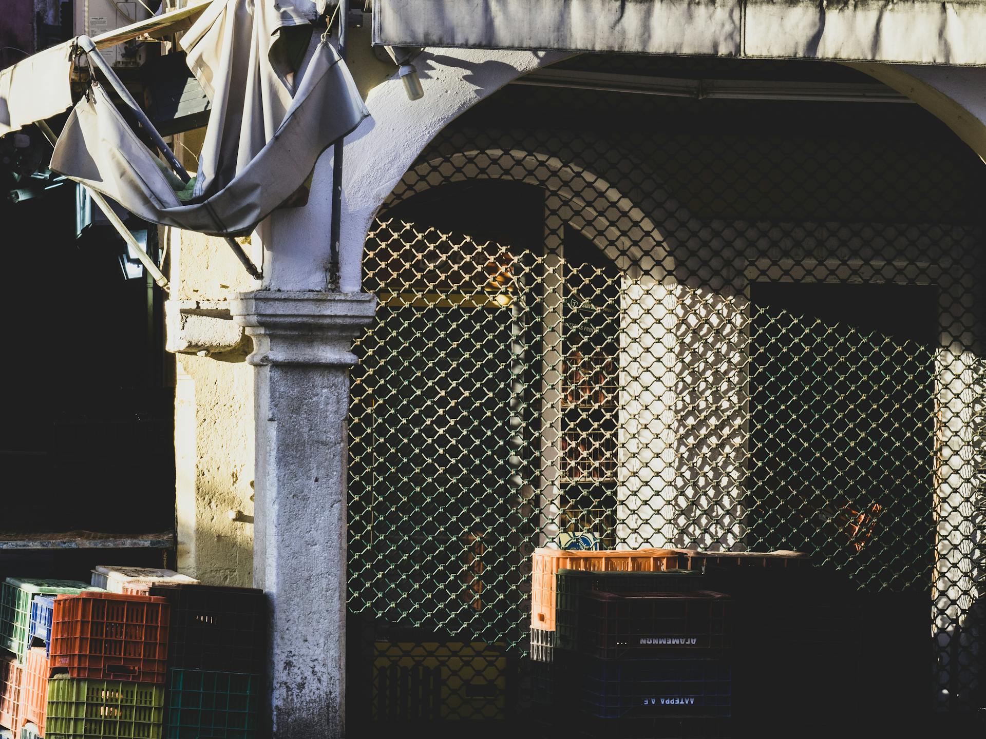 Crates Sitting under Iron Fence