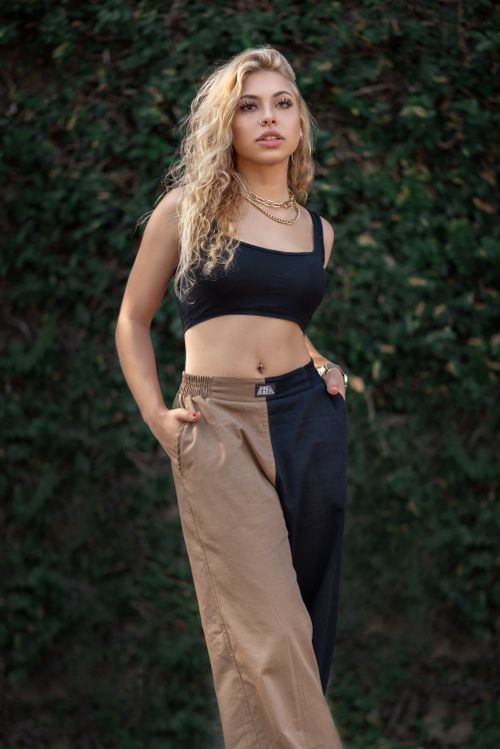 Free Fashionable young woman with curly blonde hair posing outdoors in trendy casual outfit. Stock Photo