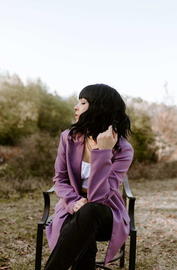 Woman Sitting On Chair In Purple Coat