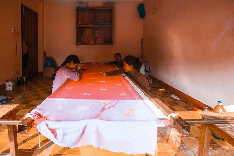 Women Embroidering Long Piece Of Cloth