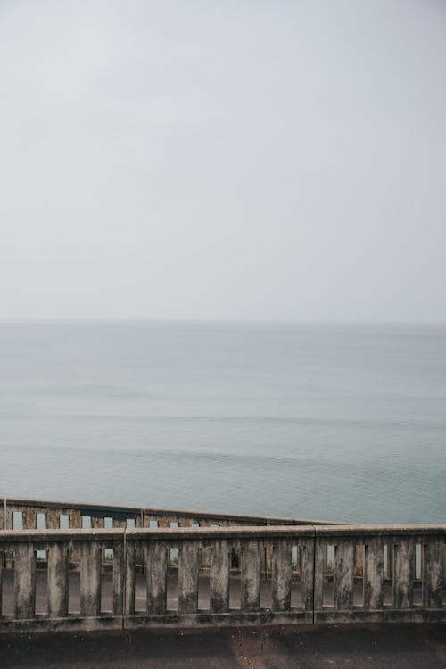Бесплатное стоковое фото с вертикальный выстрел, грязный забор, море