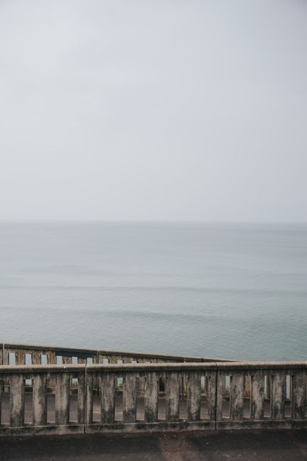 Peaceful seascape of Biarritz with calm waters and an aged fence in view.