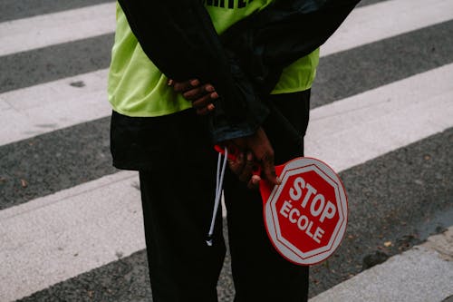 A Person Holding a Hand held Stop Sign