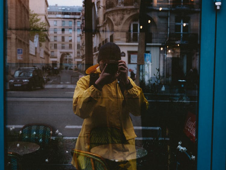 Man Taking Picture With Camera In Window