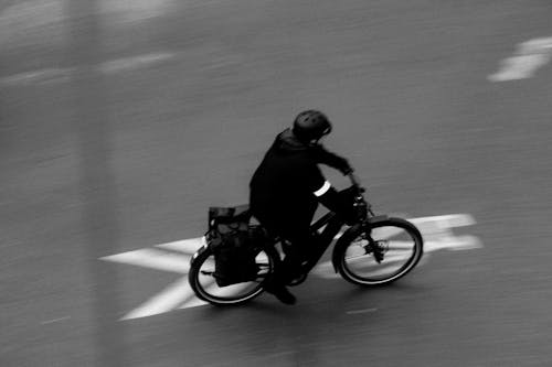 A Man in Black Jacket Riding a Bicycle