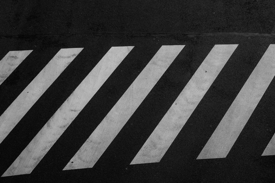 Black and white angled pedestrian crossing lines creating an abstract street pattern.