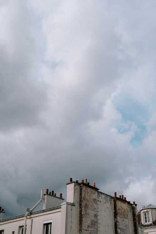 Free Overcast sky above urban building chimneys, showcasing a moody skyscape. Stock Photo