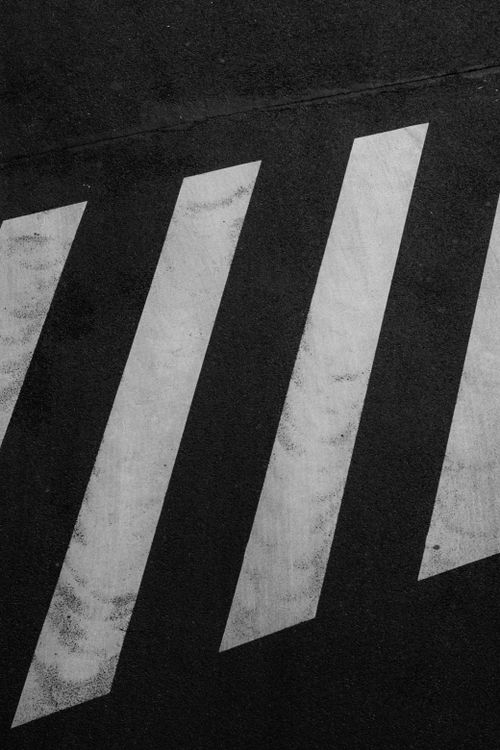 Free A minimalist black and white photo of a diagonal zebra crossing on an asphalt road. Stock Photo