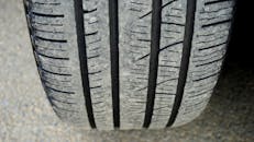 汽车轮胎胎面磨损的宏观特写镜头，清晰地展示了磨损状况与纹理细节