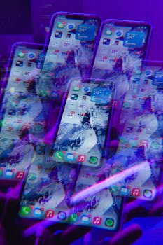 Artistic abstract photo of mobile phones with vibrant neon lighting and futuristic effects.
