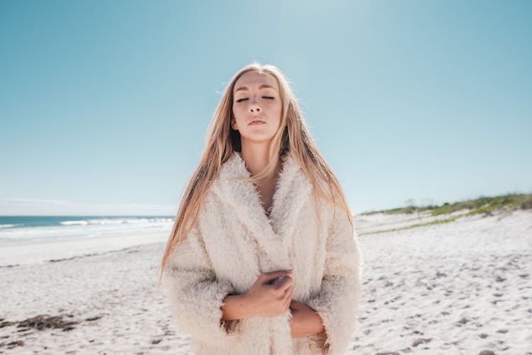 Woman In Coat On Beach