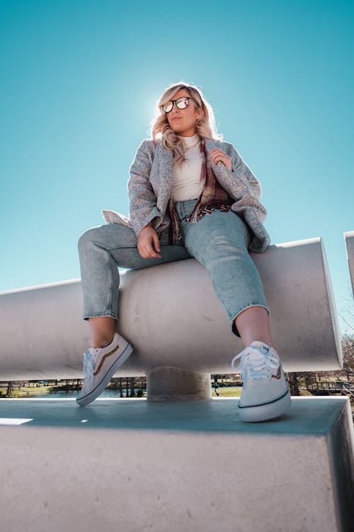 Free Woman in Denim Jeans Sitting on Concrete bench Stock Photo