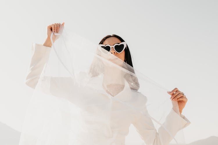 Woman In Sunglasses And White Shirt Holding White Fabric