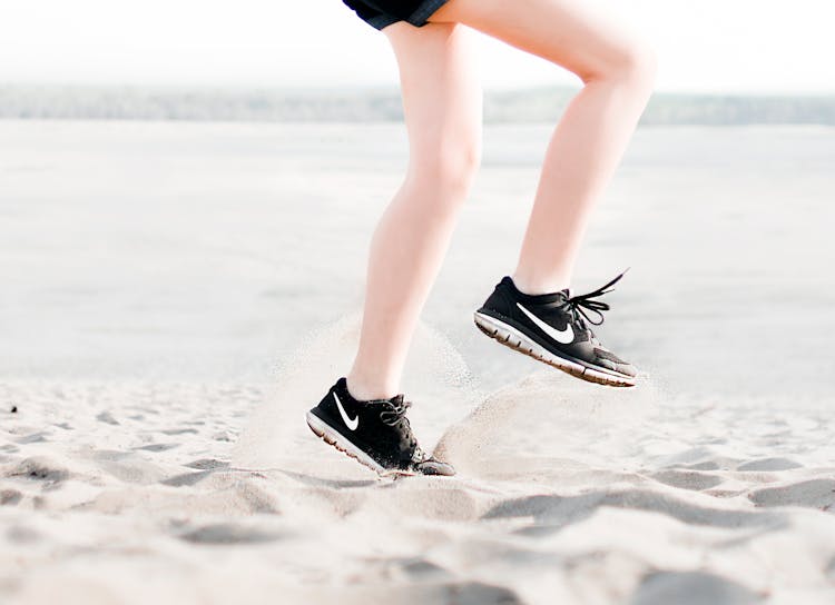 Photo Of Woman Wearing Pair Of Black Nike Running Shoes