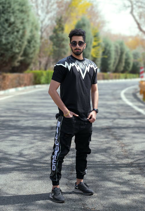 Free Man in Black Crew Neck T-shirt and Black Pants Standing on Road Stock Photo