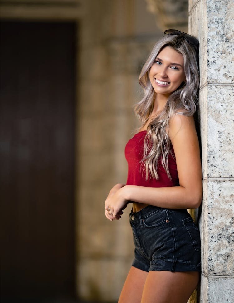 Smiling Blonde Woman By Wall